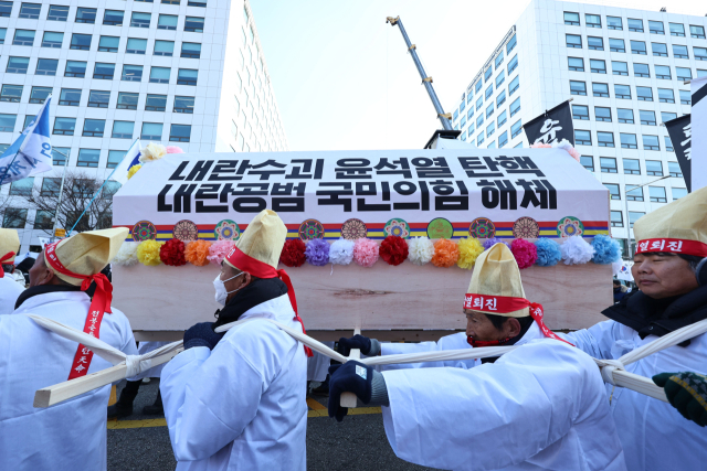 14일 서울 영등포구 여의도 국회 앞에서 열린 윤석열 대통령 탄핵 촉구 집회에서 참가자들이 상여를 운반하는 퍼포먼스를 하고 있다. 연합뉴스