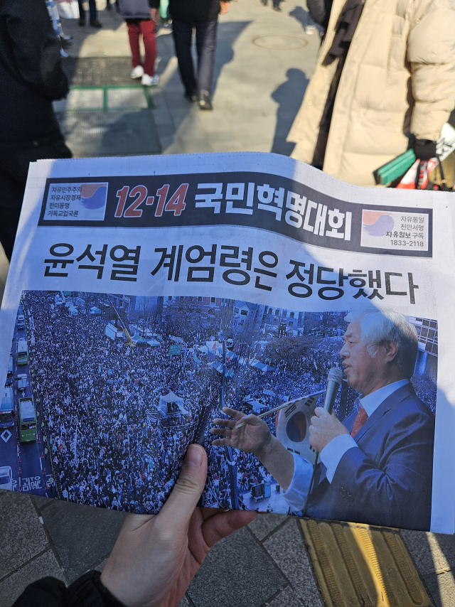 14일 서울 광화문에서 윤석열 대통령이 선포한 '12·3 비상계엄'에 대해 옹호하는 신문이 배부되고 있다. 박민주 기자