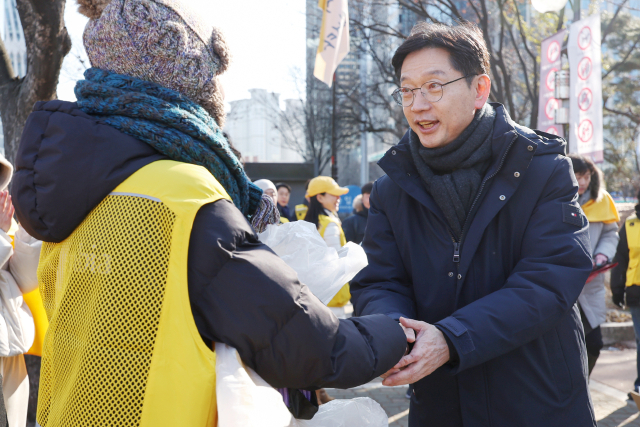 김경수 전 경남도지사가 14일 서울 여의도공원을 찾아 윤석열 대통령 탄핵 촉구 집회에 참가하는 시민들을 상대로 방한용품을 나눠준 노무현시민센터 관계자들을 만나 격려하고 있다. 뉴스1