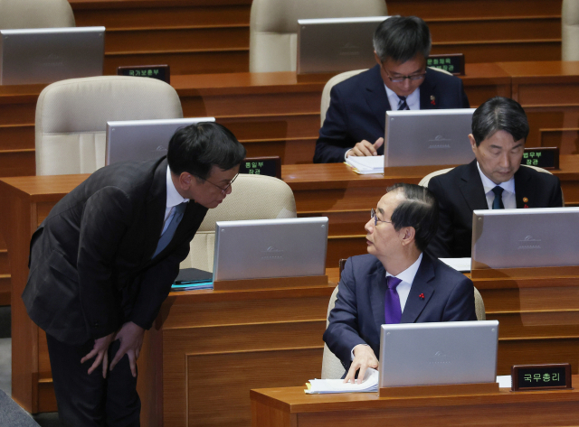 한덕수 국무총리가 13일 오후 국회 본회의에서 열린 '윤석열 대통령 위헌적 비상계엄 선포 내란행위 관련 긴급현안질문'에 참석해 최상목 부총리 겸 기획재정부 장관과 대화하고 있다. 연합뉴스.