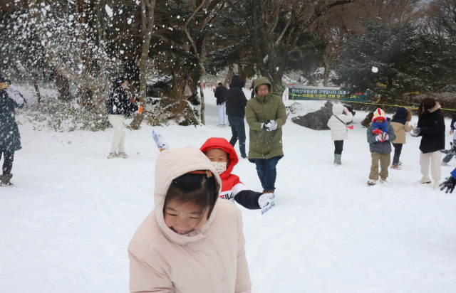 제주 방문 관광객들이 15일 오전 한라산 1100고지습지 인근 하얀 눈밭에서 눈놀이하며 설경을 즐기고 있다. 연합뉴스