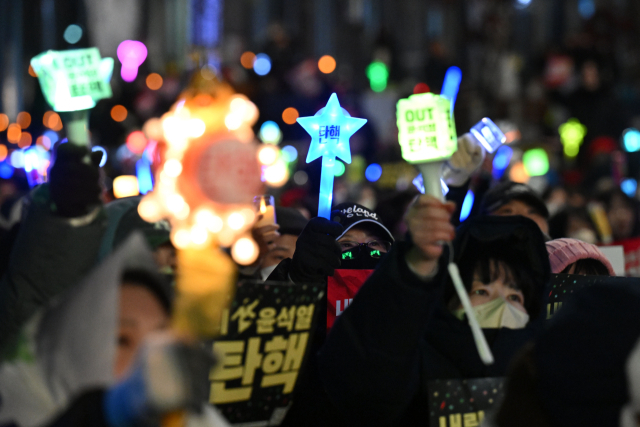 윤석열 대통령에 대한 국회의 2차 탄핵소추안 표결을 하루 앞둔 13일 오후 서울 여의도 국회 앞에서 열린 '윤석열 즉각 탄핵 촉구 촛불문화제' 참가자들이 응원봉과 손피켓을 들고 있다. 조태형 기자