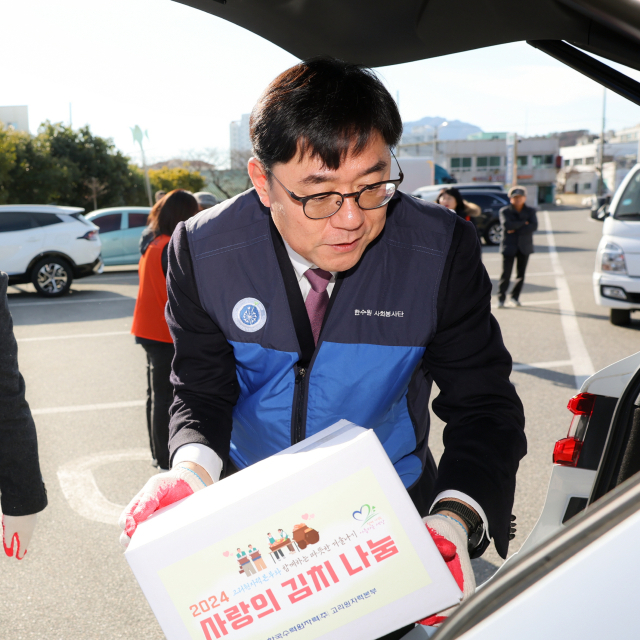 부산 기장군 고리스포츠문화센터에서 열린 ‘사랑의 김치 나눔 한마당’ 행사에 참여한 이상욱 고리원자력본부장이 준비한 김치를 전달하고 있다. 사진제공=고리원자력본부