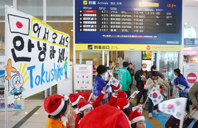 26일 일본 도쿠시마공항에서 열린 '이스타항공 도쿠시마 첫 취항' 기념 행사에서 한국 탑승객들이 도쿠시마 유치원생들의 환영을 받으며 입국장을 나서고 있다. 도쿠시마=권욱 기자 2024.12.26