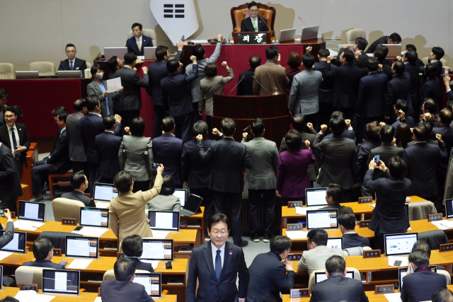 이재명 더불어민주당 대표가 27일 오후 국회 본회의에서 국민의힘 의원들이 우원식 국회의장에게 항의하는 동안 한덕수 국무총리 탄핵소추안에 투표한 뒤 자리로 향하고 있다. 연합뉴스