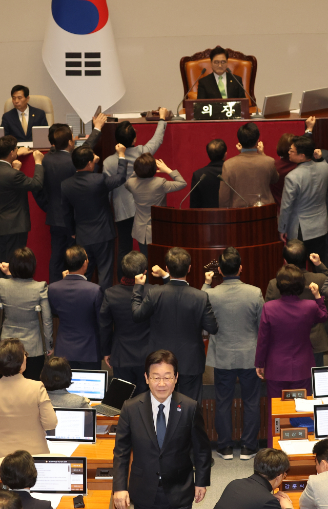 이재명 더불어민주당 대표가 지난 27일 서울 여의도 국회에서 열린 본회의에서 국민의힘 의원들이 우원식 국회의장에게 항의하는 동안 한덕수 국무총리 탄핵소추안에 투표한 뒤 자리로 이동하고 있다. 연합뉴스