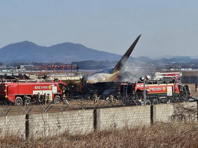 29일 오전 9시 7분께 전남 무안국제공항에서 착륙 중이던 항공기가 활주로를 이탈해 울타리 외벽을 충돌했다. 사고가 난 항공기는 태국 방콕에서 출발해 무안으로 입국하던 제주항공 7C 2216편으로, 승객과 승무원 등 175명을 태우고 있었다. 사진은 사고 현장에서 소방대원들이 화재 진압과 인명 구조를 하고 있는 모습.연합뉴스