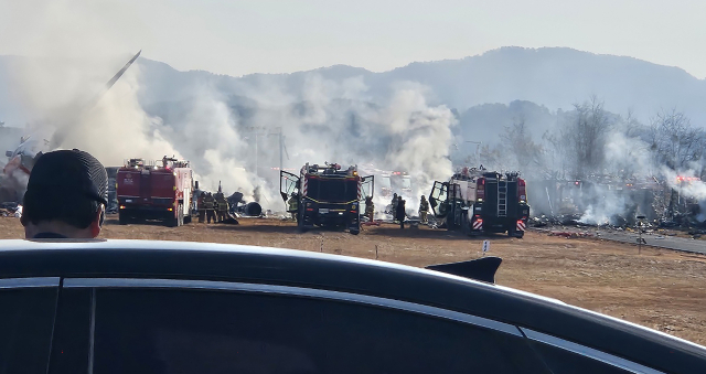 29일 오전 9시 7분께 전남 무안국제공항에서 착륙 중이던 항공기가 활주로를 이탈해 울타리 외벽을 충돌했다. 사고가 난 항공기는 태국 방콕에서 출발해 무안으로 입국하던 제주항공 7C 2216편으로, 승객과 승무원 등 175명을 태우고 있었다. 사진은 사고 현장에서 소방대원들이 화재 진압과 인명 구조를 하고 있는 모습. 연합뉴스