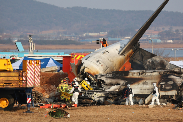 29일 전남 무안국제공항에서 발생한 제주항공 여객기 충돌 폭발 사고 현장에서 소방구급대원이 사고 여객기를 수색하고 있다. 무안=연합뉴스