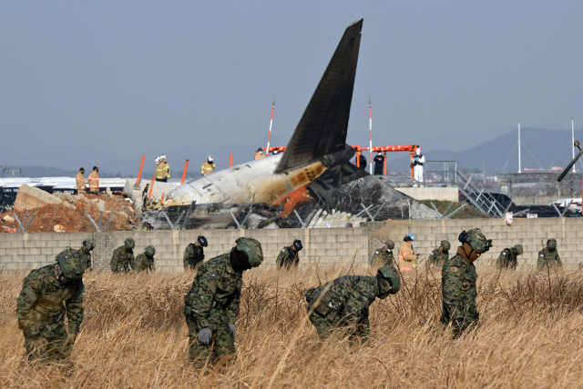 29일 전남 무안군 무안국제공항에서 발생한 제주항공 여객기 충돌 폭발 사고 현장에서 군 관계자들이 현장 수습을 하기 위해 대기하고 있다. 성형주 기자 2024.12.29