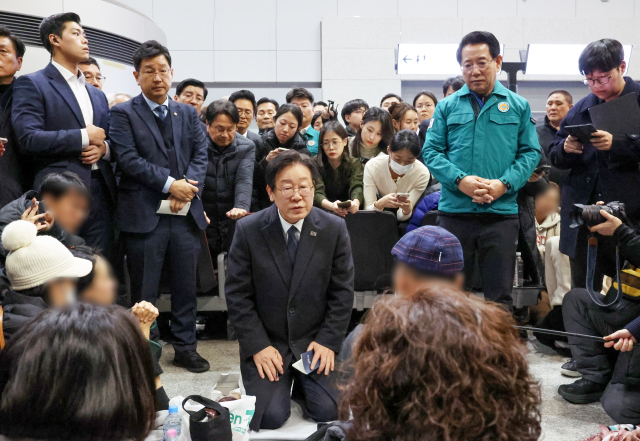 이재명 더불어민주당 대표가 29일 오후 전남 무안국제공항에서 무릎을 꿇은 채 제주항공 여객기 폭발사고 탑승객 가족들을 위로하고 있다. 연합뉴스