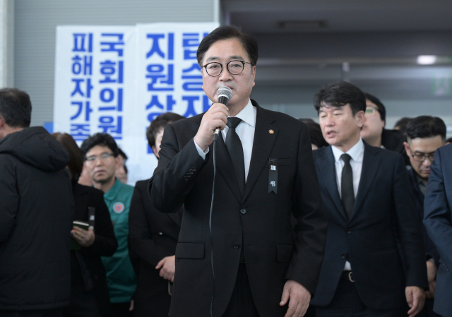 우원식 국회의장이 30일 오후 전남 무안군 무안국제공항에서 제주공항 참사 피해자 유가족에게 위로의 말을 전하고 있다. 연합뉴스