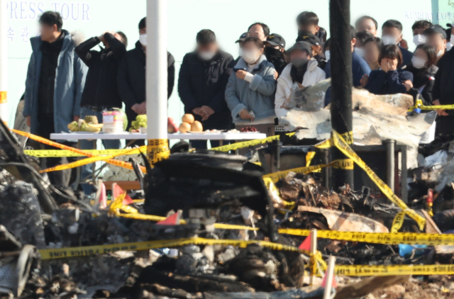 1일 전남 무안군 무안국제공항 제주항공 여객기 참사 현장을 찾은 탑승객 유가족들이 간소한 상을 차려두고 희생자들에게 새해 인사를 하고 있다. 연합뉴스