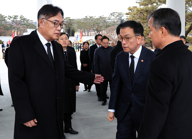 최상목 대통령 권한대행 부총리 겸 기획재정부 장관이 2025년 새해 첫날인 1일 국립서울현충원을 찾아 현충탑 참배 뒤 정진석 대통령 비서실장과 대화하고 있다.연합뉴스