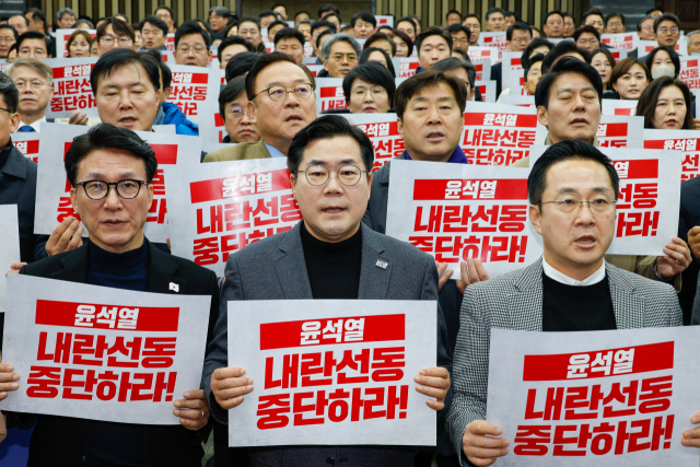 박찬대 더불어민주당 원내대표를 비롯한 의원들이 5일 오후 서울 여의도 국회에서 열린 비상의원총회에 참석해 '윤석열 내란선동 중단하라'라고 적힌 피켓을 든채 구호를 외치고 있다. 앞줄 왼쪽부터 김민석 최고위원, 박 원내대표, 박성준 원내수석부대표. 뉴스1