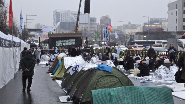 6일 서울 용산구 한남동 대통령 관저 인근 도로에서 진보 측 지지자들이 철야 농성 후 앉아있다. 이승령 기자