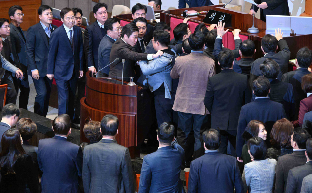 국민의힘 의원들이 12월 27일 국회 본회의에서 우원식 국회의장이 '한덕수 국무총리 탄핵소추안' 의결정족수를 재적 과반 이상으로 정하고 투표 개시를 선언하자 의장석을 둘러싸고 격렬하게 항의하고 있다. 오승현 기자