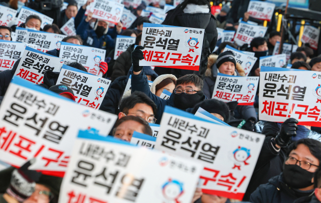 한국노동조합총연맹(한국노총) 조합원들이 10일 오후 서울 용산구 한남동 대통령 관저 앞에서 열린 '윤석열 체포·구속 촉구 한국노총 결의대회'에서 팻말을 들고 있다. 연합뉴스