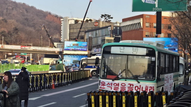 12일 서울 용산구 한남동 대통령 관저 인근에 진보 단체의 난방 버스 뒤로 보수 단체의 무대가 설치돼있다. 이승령 기자