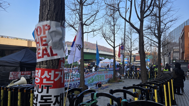 12일 서울 용산구 한남동 대통령 관저 인근에 모인 진보 단체 집회 현장에 보수 단체 측이 부착한 피켓이 붙어있다. 이승령 기자