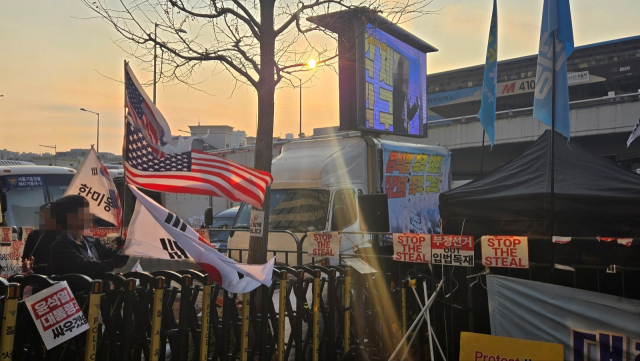 12일 서울 용산구 한남동 대통령 관저 인근에서 보수 단체 지지자들이 탄핵 찬성 집회 방향으로 태극기와 성조기를 흔들고 있다. 이승령 기자