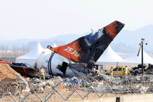 제주항공 여객기 참사 16일째인 13일 무안국제공항 사고 현장에서 소방 대원들이 기체에 덮인 방수포를 걷어내고 있다. 연합뉴스