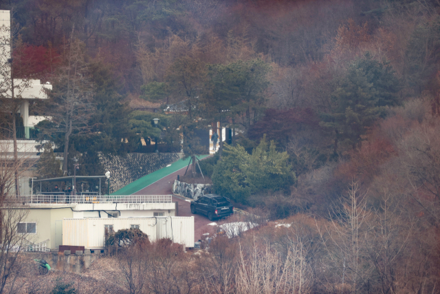 고위공직자범죄수사처(공수처)가 윤석열 대통령에 대한 체포영장을 재발부받은 지 일주일을 맞은 13일 서울 용산구 한남동 대통령 관저에서 경호처 대테러과 소속으로 추정되는 직원이 순찰하고 있다. 연합뉴스