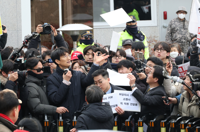 차성안 서울시립대 법학전문대학원 교수 등이 13일 오후 서울 용산구 한남동 관저 앞에서 경호처 관계자에게 부당지시거부 소명서를 전달하려고 하자 보수단체 집회 참가자가 관련 서류를 집어 던지고 있다. 연합뉴스