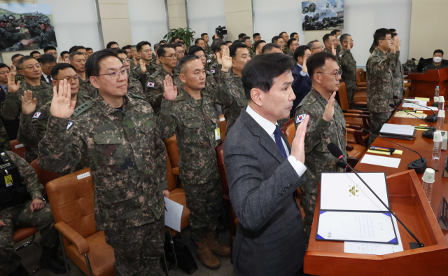 김선호 국방부 차관을 비롯한 군 관계자들이 14일 국회에서 열린 ‘윤석열 정부의 비상계엄 선포를 통한 내란 혐의 진상규명 국정조사 특별위원회’ 전체회의에 증인으로 출석해 증인 선서를 하고 있다. 연합뉴스