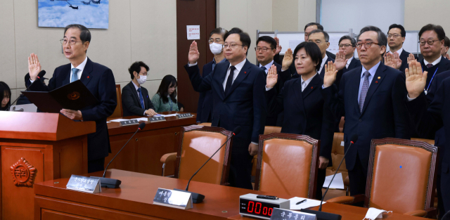 한덕수(왼쪽) 국무총리가 15일 국회에서 열린 내란 혐의 진상규명 국정조사 특위에서 국무위원들 및 대통령실 참모진과 증인 선서를 하고 있다. 오승현 기자