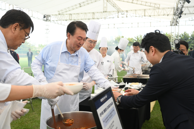 윤석열 대통령이 2024년 5월 24일 서울 용산 대통령실 청사 잔디마당에서 열린 ‘대통령의 저녁 초대’ 출입기자단 초청 만찬 간담회에서 출입기자에게 김치찌개를 배식하고 있다. 연합뉴스