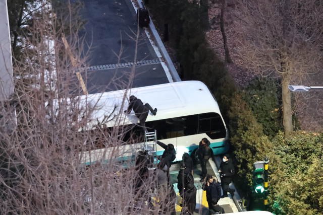 고위공직자범죄수사처(공수처)와 경찰이 윤석열 대통령에 대한 2차 체포영장 집행에 나선 15일 서울 용산구 한남동 대통령 관저 입구에서 경찰이 사다리로 차벽을 넘고 있다. 연합뉴스