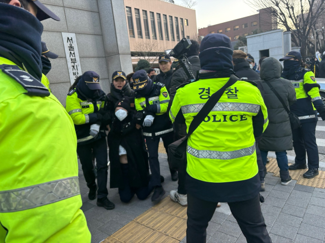 17일 경찰이 서울 마포구 서부지법 정문 앞에서 고성을 지르던 윤석열 대통령 지지자를 강제 퇴거 조치하고 있다. 정다은 기자