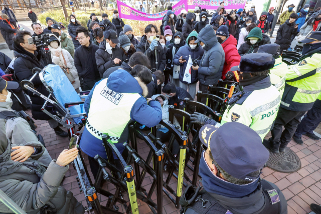 윤석열 대통령의 영장심사가 실시되는 18일 오전 서울 마포구 서울서부지방법원 앞에서 집회를 이어가던 윤 대통령의 지지자가 경찰의 강제해산 과정에서 실신해 구급대원이 출동해 있다. 뉴스1