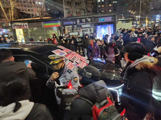 내란 우두머리 혐의로 체포된 윤석열 대통령의 구속 전 피의자심문(영장실질심사)이 종료된 18일 밤 서울 마포구 공덕역 인근에서 윤 대통령 지지자들이 고위공직자범죄수사처(공수처) 추정 차량의 앞을 막고 있다. 연합뉴스