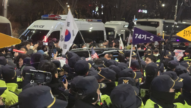 18일 서울서부지법 앞에서 흥분한 윤 대통령 지지자들이 공수처 검사가 탑승한 차량을 가로막고 흔들고 있다. 이승령 기자