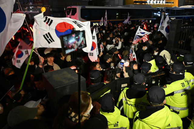 서울 마포구 서울서부지방법원에서 18일 '내란 우두머리' 혐의를 받는 윤석열 대통령이 구속 전 피의자 심문(영장실질심사)을 받고 있는 가운데 지지자들이 법원 담장 너머로 시위를 하고 있다. 조태형 기자