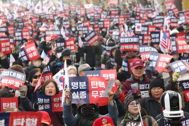 윤석열 대통령의 탄핵심판 3차 변론이 열리는 21일 서울 종로구 헌법재판소 인근에서 윤 대통령 지지자들이 '명분실종 탄핵무표'를 주장하고 있다. 연합뉴스