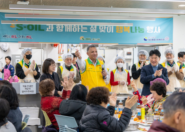 안와르 알 히즈아지(가운데) 에쓰오일 CEO가 ‘2025 설맞이 사랑의 떡국 나누기’ 행사에서 손 하트를 하면서 기념촬영을 하고 있다. 사진제공=에쓰오일