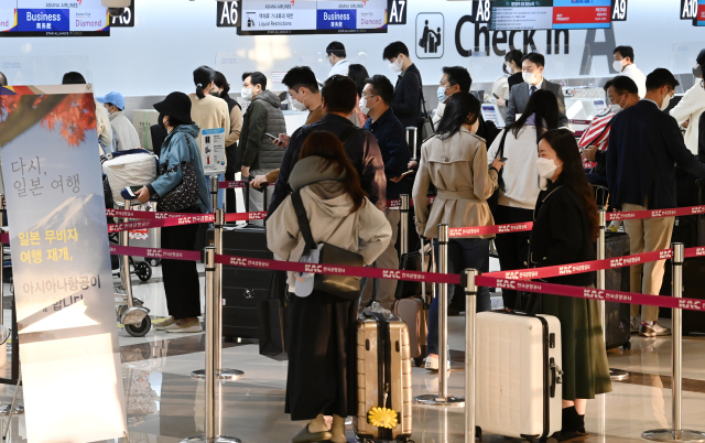 김포국제공항 아시아나항공 국제선 카운터에서 탑승객들이 김포-하네다 항공편 탑승 수속을 위해 길게 줄을 선 채 순서를 기다리고 있다. 권욱 기자