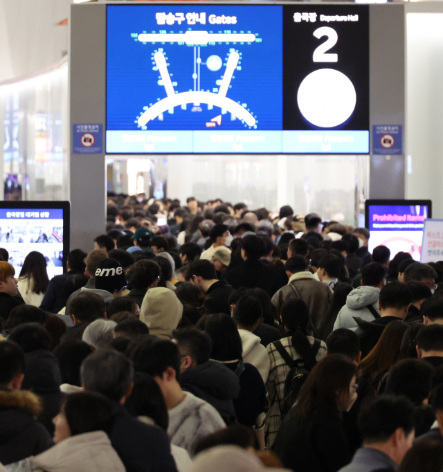 설 명절 연휴를 앞둔 23일 오전 인천국제공항 제1여객터미널 출국장에서 승객들이 탑승 수속을 위해 줄을 서고 있다. 연합뉴스