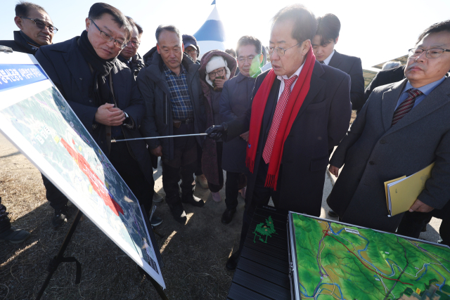 홍준표 대구시장이 15일 군위군 소보면 내의리 대구경북통합신공항 예정지를 방문해 대구시 신공항추진단장으로부터 사업 추진 현황을 보고받고 지시하고 있다. 2025.1.15 연합뉴스