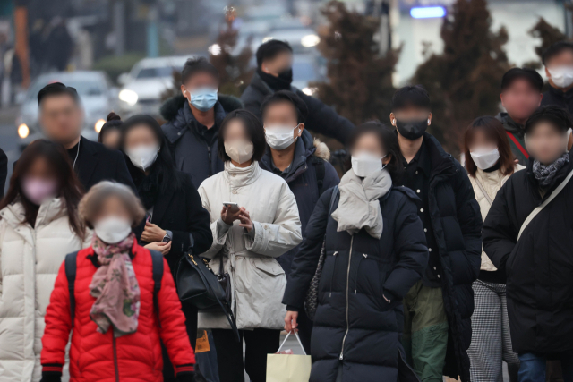 22일 오전 서울 시청 앞 부근에서 시민들이 마스크를 쓰고 출근하고 있다. 연합뉴스