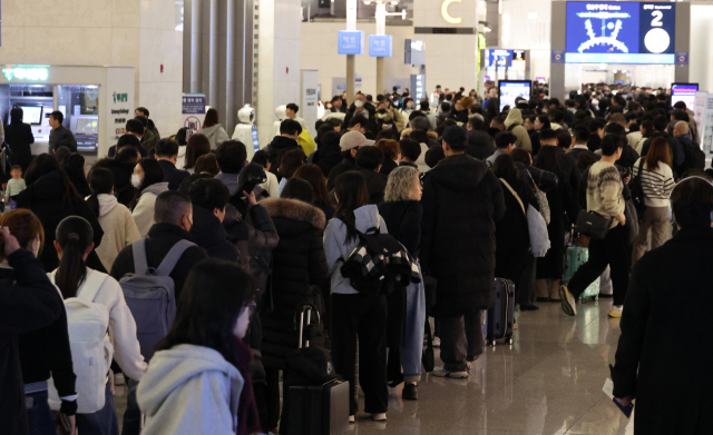 설 명절 연휴를 앞둔 23일 오전 인천국제공항 제1여객터미널 출국장에서 승객들이 탑승 수속을 위해 줄을 서고 있다. 연합뉴스.