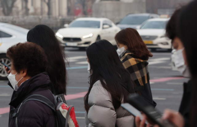 22일 오전 서울 시청 앞 부근에서 시민들이 마스크를 쓰고 출근하고 있다. 연합뉴스