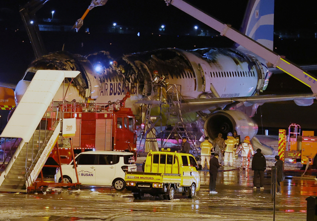 28일 오후 김해공항 계류장에서 승객 170명과 승무원 6명을 태우고 이륙을 준비하던 홍콩행 에어부산 항공기 BX391편 내부에서 불이 나 소방대원들이 진화 작업을 하고 있다. 연합뉴스