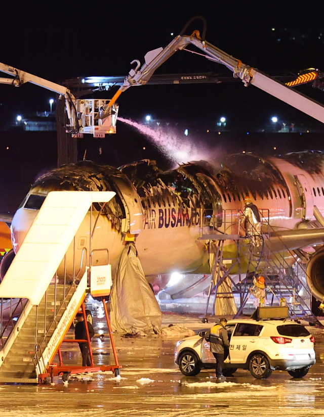 28일 오후 김해공항 계류장에서 승객 170명과 승무원 6명을 태우고 이륙을 준비하던 홍콩행 에어부산 항공기 BX391편 내부에서 불이 나 소방대원들이 진화 작업을 하고 있다. 연합뉴스