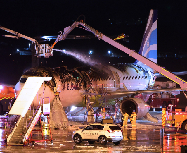 28일 오후 김해공항 계류장에서 승객 170명과 승무원 6명을 태우고 이륙을 준비하던 홍콩행 에어부산 항공기 BX391편 내부에서 불이 나 소방대원들이 진화 작업을 하고 있다. 연합뉴스.