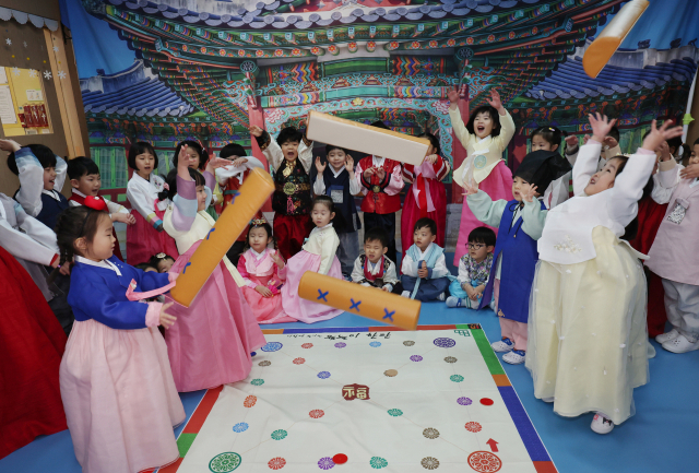 설설 연휴를 앞둔 23일 부산 부산진구청 어린이집에서 원생들이 한복을 곱게 차려입고 윷놀이하며 명절 문화 체험을 하고 있다. 연합뉴스