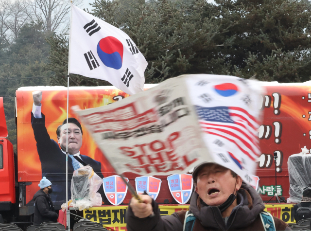 31일 오전 경기도 의왕시 서울구치소 앞에서 윤석열 대통령 지지자들이 태극기와 성조기를 흔들고 있다. 연합뉴스